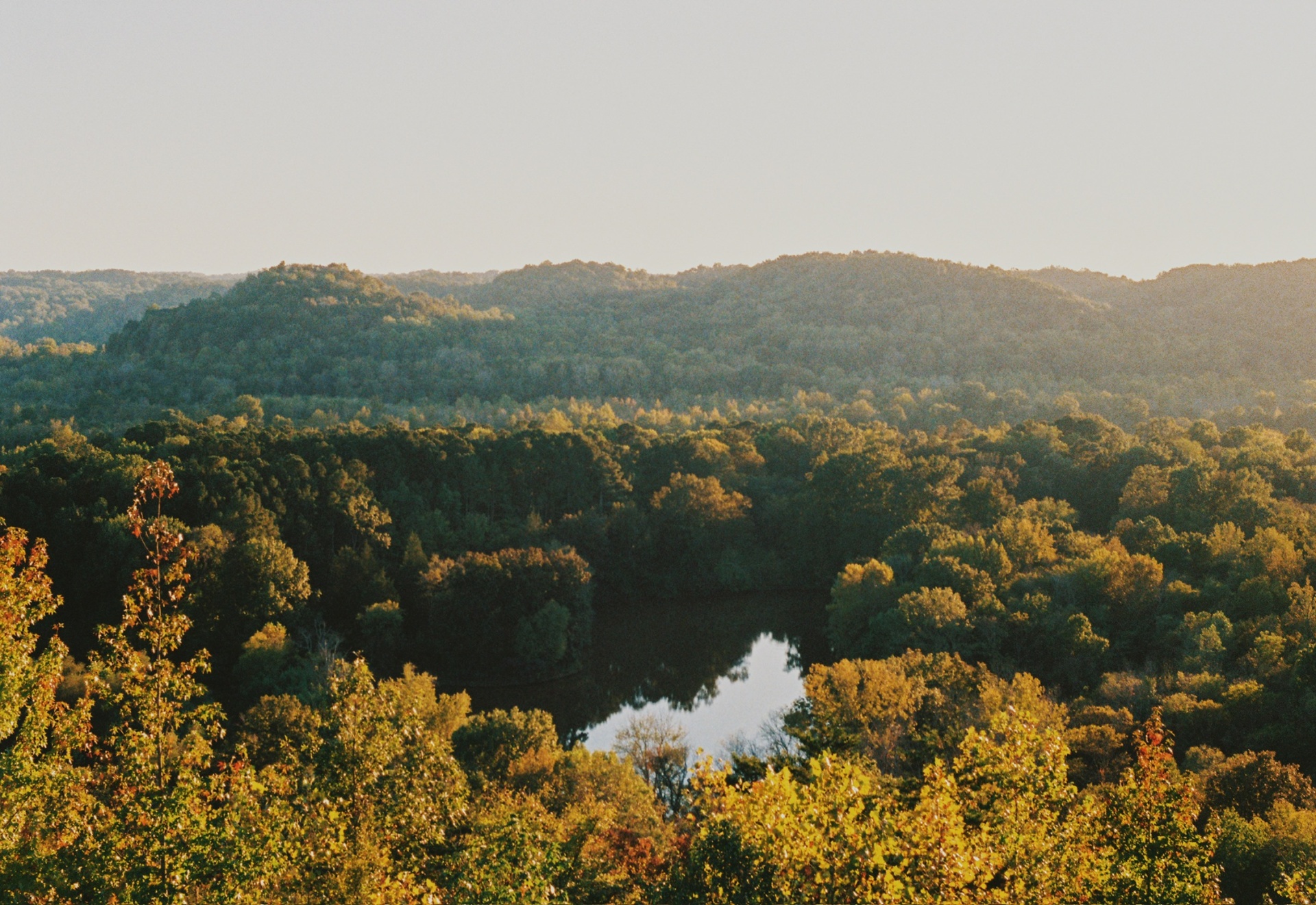 Hills rolling out to a hidden lake in the valley at golden hour