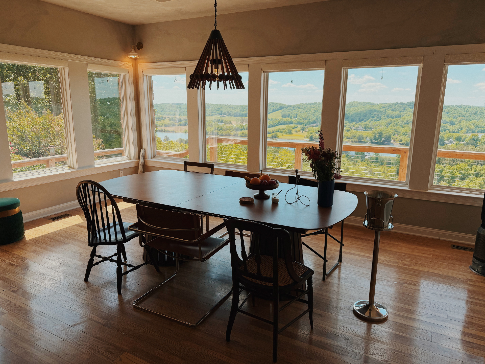 Dining room framed by tall windows overlooking the lake and rolling hills